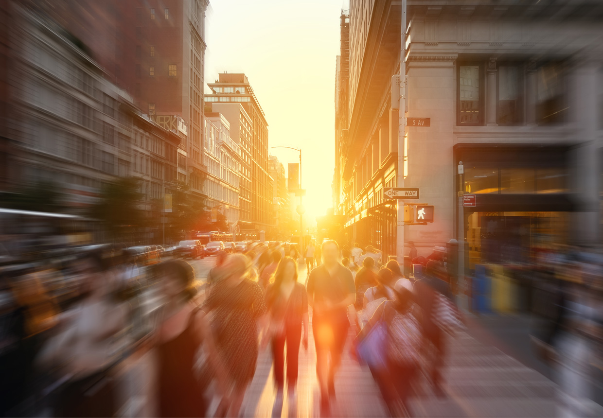 Crowd walking along Fifth Avenue at sunset