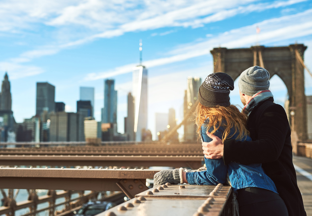 Couple on Brooklyn Bridge admiring the Manhattan skyline
