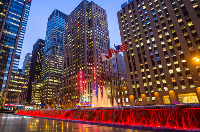Radio City Music Hall at dusk with illuminated fountains