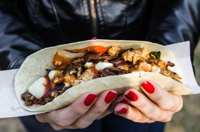 Hands holding a loaded street food taco