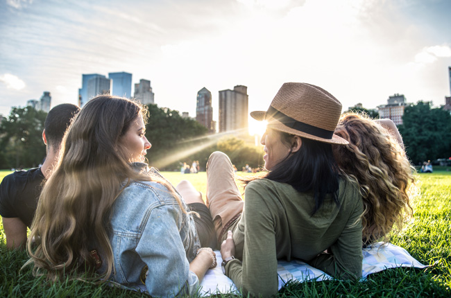 Friends relaxing in Central Park at sunset